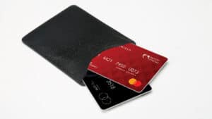 Close-up of a black wallet with a red credit card and a black card inside.
