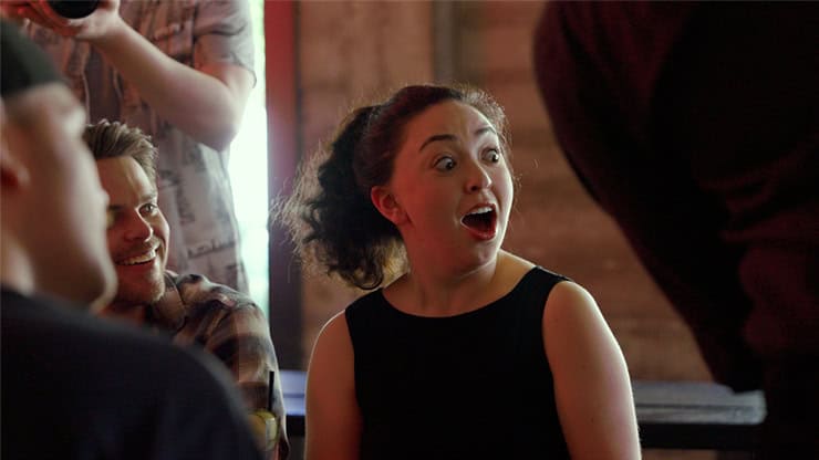 Woman surprised by magic trick "Liquify" by Tobias Dostal at a magic show.