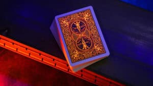 Bicycle neon orange rider back playing cards with intricate design under neon lighting.