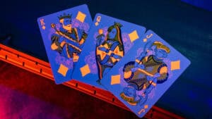 Bright neon orange Bicycle playing cards featuring royal figures on a dark background.