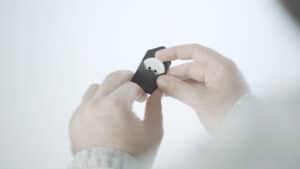 Close-up of a person holding the Paradox Button magic trick device.