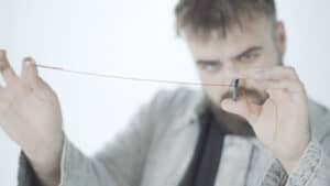 Close-up of a man demonstrating the Paradox Button magic trick by Julio Montoro and Ultrabello.