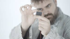 Close-up of a man holding a mysterious paradox button for magic tricks.