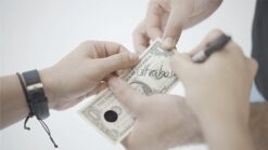 Close-up of a magic trick involving a dollar bill and a coin, performed by magicians Julio Montoro,.