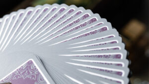 Reflections Ponder pink playing cards fanned out, showcasing intricate designs by Emily Sleights.