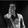 Performer holding Dual Pad magic trick device in front of camera.