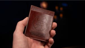 Close-up of a hand holding a leather passport-style magic prop for illusions.