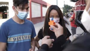Impressive magic trick performed outdoors with two spectators wearing masks.