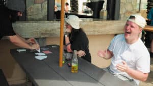Young man performing magic with GHOST DECK during a card trick at a social gathering.