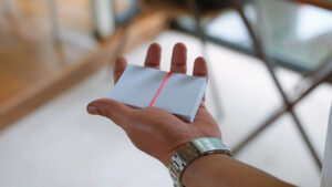 Close-up of a hand performing a magic card trick with a deck of cards.
