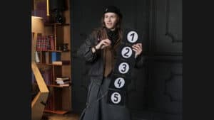 Elegant magician performing a card trick with Prestige Pro in a sophisticated setting.