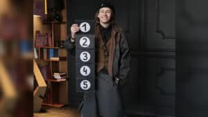 Performer demonstrating a card trick with the Prestige Pro parlor illusion by Hide & Sergey Koller.