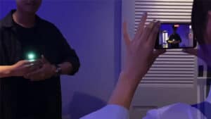 Close-up of a person performing a magic trick with a glowing object in a dark room.