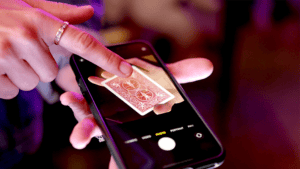 Person using the Digital Flap app on smartphone with a playing card.