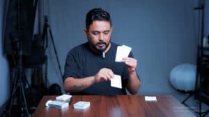 Magician performing a card trick with playing cards for an audience.