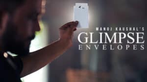 Man holding a mysterious white envelope for magic tricks, promoting Glimpse Envelopes.
