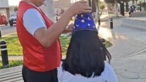 Performer performing a magic trick with a wizard hat during a street magic show.