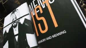 Close-up of a magician performing a card trick with a black-and-white photo.