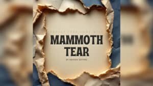 Close-up of torn paper revealing "Mammoth Tear" magic trick title.