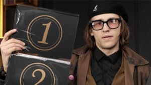 Performer showcasing Prestige Pro stage magic trick with numbered cards.