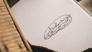 Up of a handwritten signature on a white paper, showcasing artistic calligraphy.