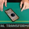 Close-up of a magic trick with a smartphone and playing cards for digital transformation illusion.