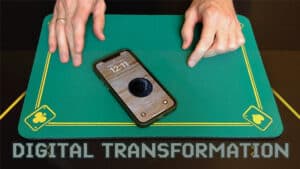 Close-up of a magic trick with a smartphone and playing cards for digital transformation illusion.