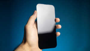 Hand holding a smartphone with an extra screen, magic trick by João Miranda and Julio Montoro.