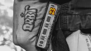 Close-up of CC Orbit 4th Edition playing cards with a tattooed hand holding the deck.