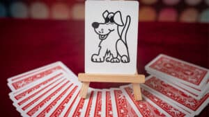 Dog illustration on a card with a deck of cards spread out behind it.