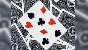 Close-up of a playing card with hearts, spades, diamonds, and clubs from a magic trick.