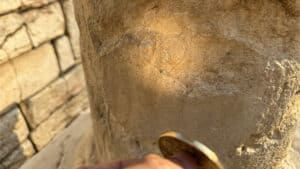 Close-up of the Bronze Enigma magic prop used in a card trick performance.