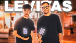 Magicians performing levitation trick with playing cards in a magic show.