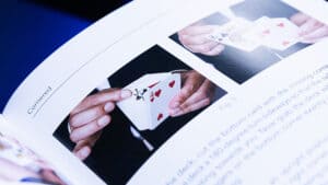 Close-up of a magician performing a card trick with playing cards.