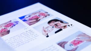Person performing a magic trick with a pink cloth and a card, demonstrating illusion skills.
