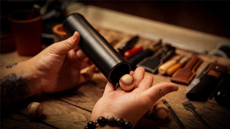 Performing The Chop Tube magic trick with a baseball and tube setup.