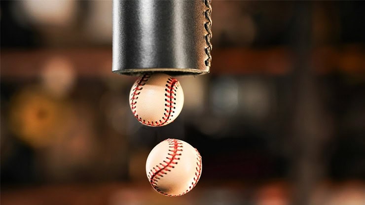 Close-up of baseballs dropping through the Chop Tube magic trick.
