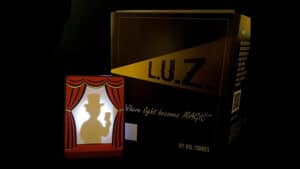 Close-up of the L.U.Z. magic trick box with silhouette figure and stage curtain backdrop.