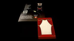 Close-up of a magic trick card box with stage curtain design for illusions.