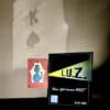 Close-up of L.U.Z. magic trick card and Playtime Magic sign for illusion performance.