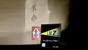Close-up of L.U.Z. magic trick card and Playtime Magic sign for illusion performance.