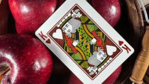 Close-up of King of Hearts playing card on red apples for magic tricks.
