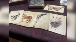 Card trick setup with butterfly-themed cards and mysterious props for magic performance.