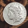Close-up of a large silver Morgan coin used in magic tricks, with detailed engravings.