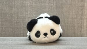 Plush panda transforming into raccoon during magic trick performance.