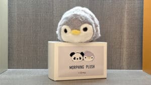 Plush toy transforming from panda to penguin, showcased on display.