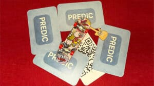 Prediction card game with colorful cards and a skateboard on a red surface.