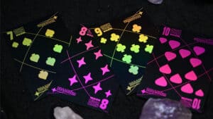 Black holographic moon playing cards with vibrant neon suits for magic performances and card tricks.