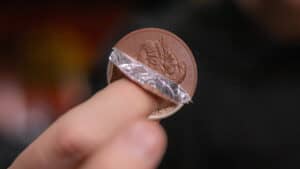 Close-up of a coin with foil covering, performing a magic trick.