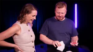 Magician performing the HEX card trick with a woman in a magic show.